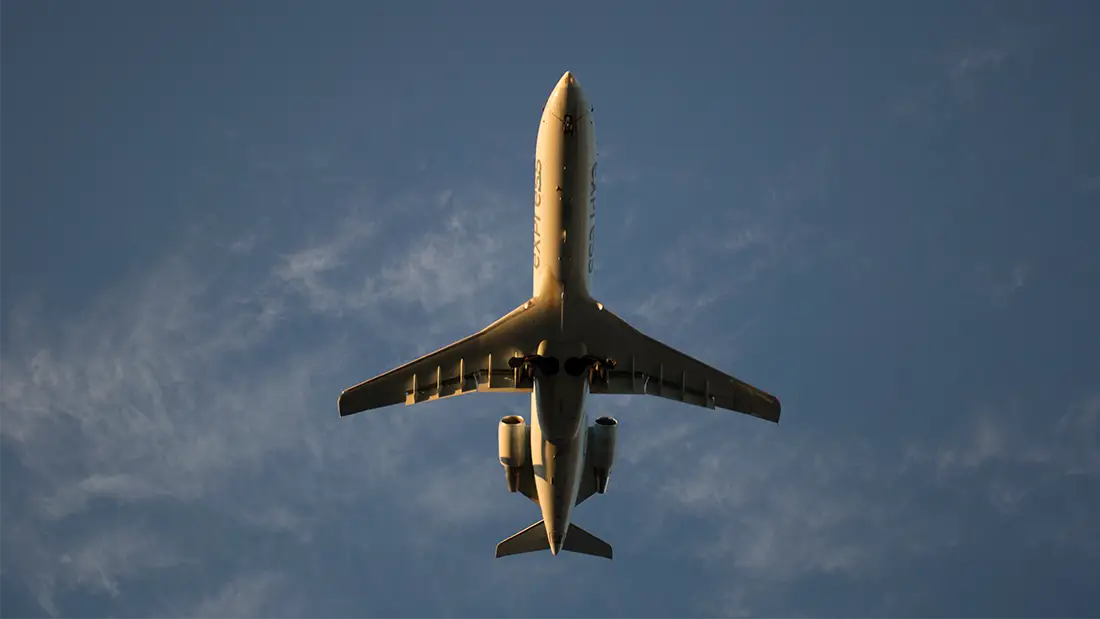 Vue de dessous d'un avion en plein ciel, métaphore de la validation du product-market fit d'un SaaS avant sa phase de croissance.